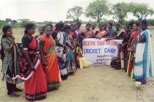 A group of women surrounding a sign that reads "Cricket Camp"