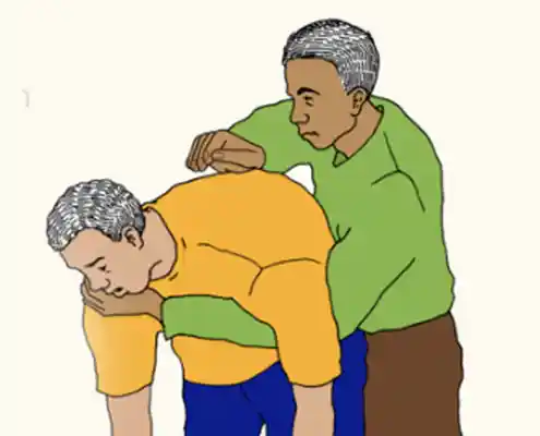 Two men, one man is helping to loosen congestion of another man by rubbing his back with his the heel of his hand.