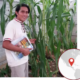 A man from Asecsa stands in a garden holding a copy of Salud Ambiental. There is a locus map with a marker pointing to Guatemala.