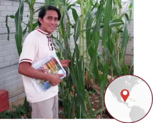 A man from Asecsa stands in a garden holding a copy of Salud Ambiental. There is a locus map with a marker pointing to Guatemala.