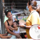 A health activist from LIKHAAN in the Philippines talks to a young woman and her child on the street.