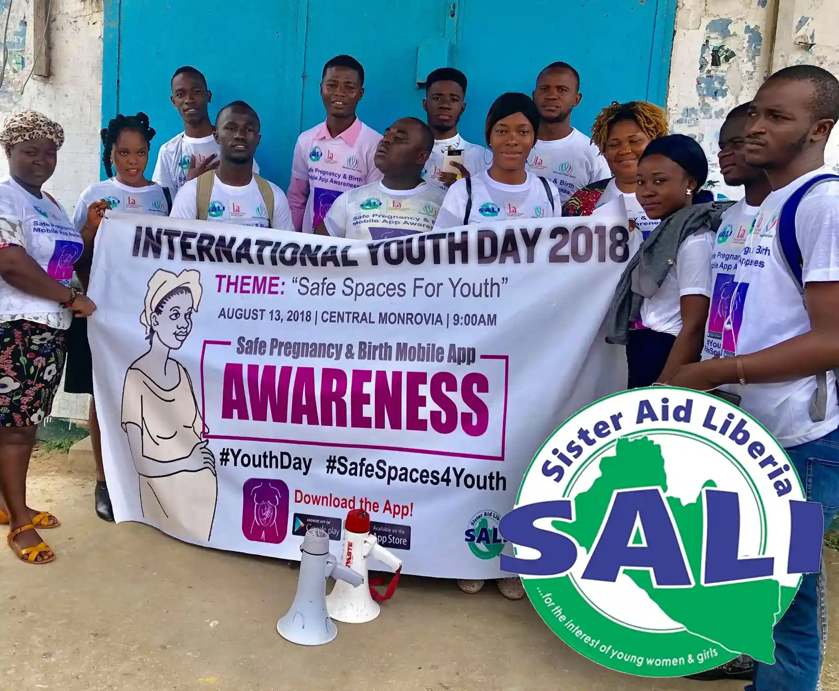 A group of people in Africa wear matching t-shirts and hold a banner supporting International Youth Day 2018.
