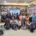 a group photo of men, women, and children in a meeting room. They stand in front of a screen that reads "Epilepsy Foundation Welcomes You"